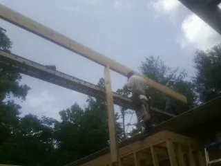 Carpenter setting a ridge beam over a new addition frame — Ice Dam Removal by Roofing Brothers in Fort Recovery