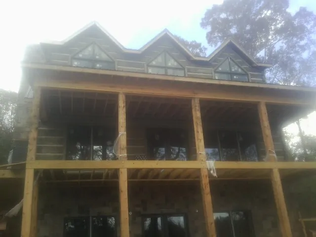 Dormers and porch framing on a large log home under construction — Roof Coating work by our crew in Fort Recovery